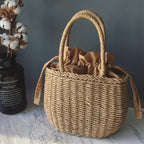 Panier artisanal en paille utilisé comme sac à main