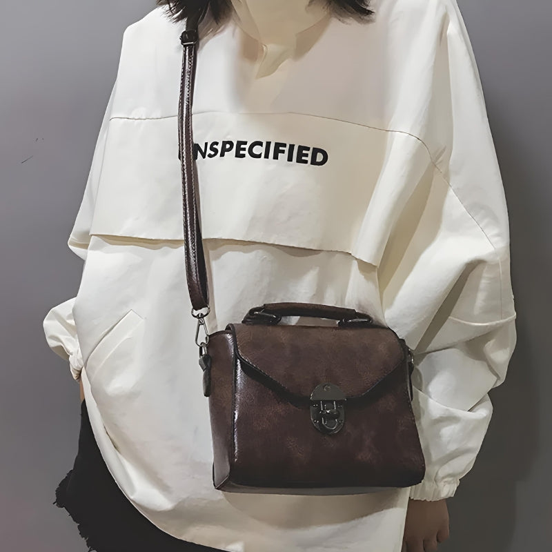 Petit sac cartable féminin porté à la main