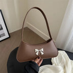 Sac baguette de style glamour agrémenté d’un nœud décoratif