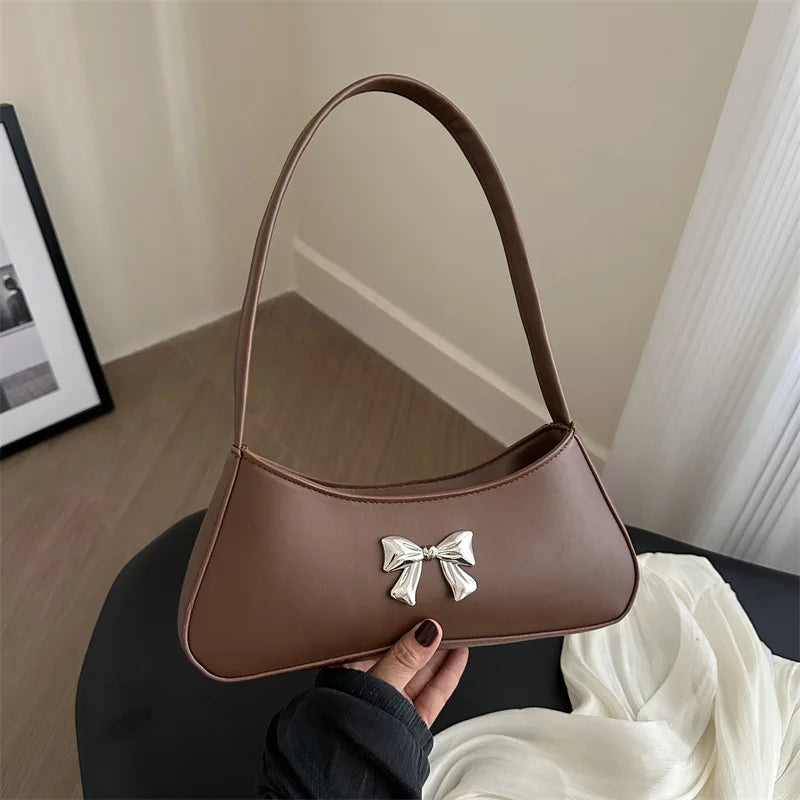 Sac baguette de style glamour agrémenté d’un nœud décoratif