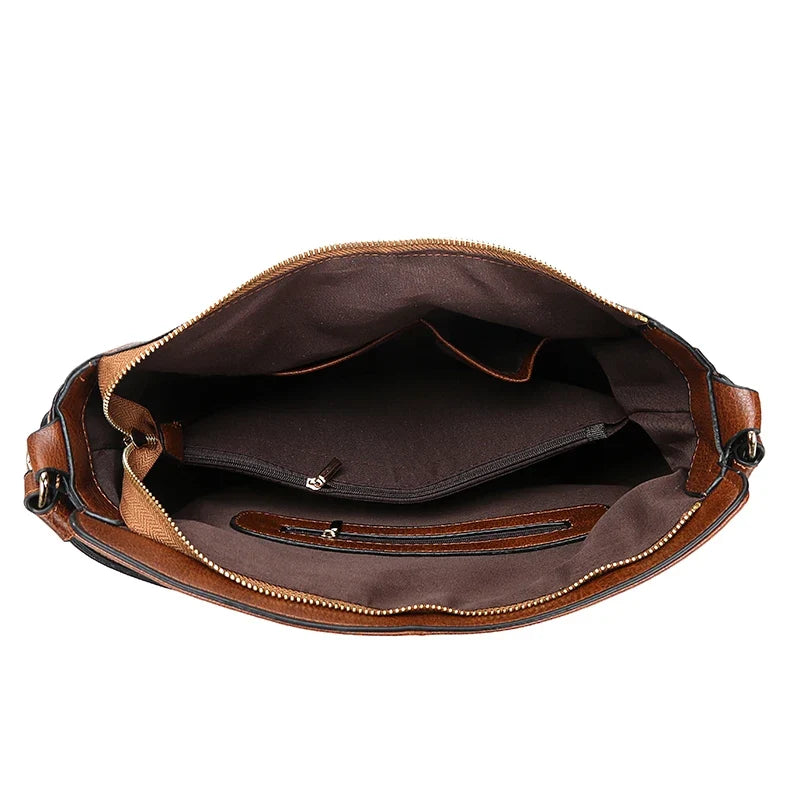 Sac bandoulière brun porté à la main