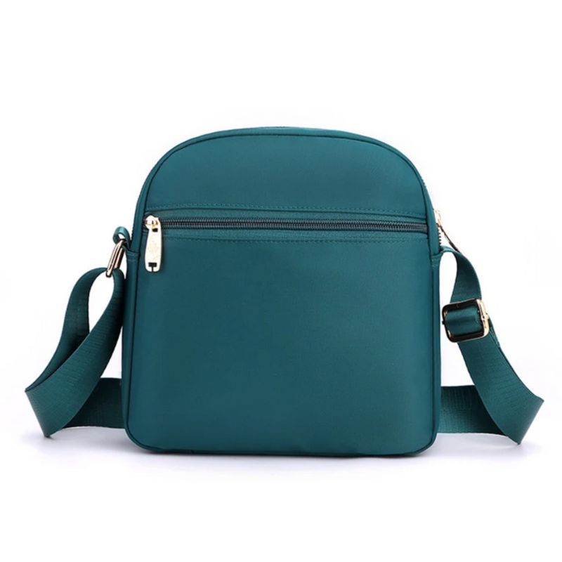 Sac féminin à nombreuses poches porté en bandoulière